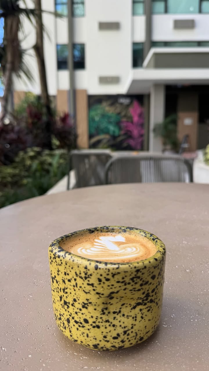Latte servido en el espacio exterior de LaVidé Coffee en Condado